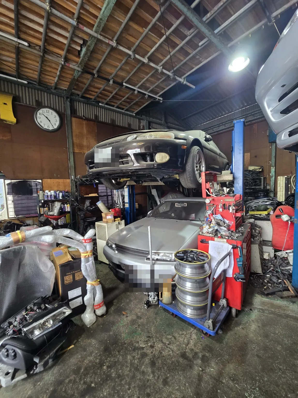 Japanese automotive workshop photographed by the Hashi Auto founder; visible license plates obscured